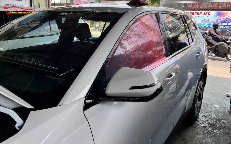 Dán phim cách nhiệt xe 7 chỗ 3M chính hãng xịt nước lên phim phản quang và chuyển màu sang ánh đỏ